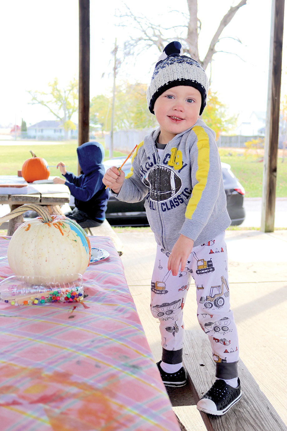 Three-year-old Flynn Snyder decorates his pumpkin Thursday with family and friends. The tyke was excited to be at Linden's Bulldog Park for pumpkin painting through the event sponsored by the Linden Library, saying "it's cold" but enjoying the experience nonetheless.